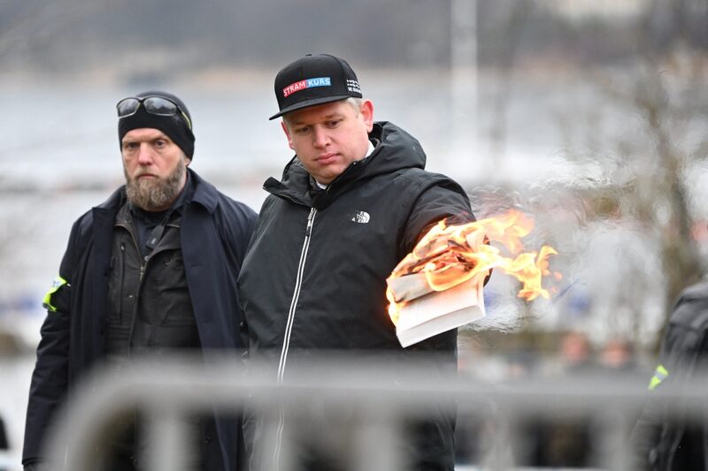 Politikus ekstrem kanan Denmark Rasmus Paludan membakar salinan kitab suci Alquran dalam demonstrasi di Stockholm, Swedia, 21 Januari 2023. (Foto: Reuters)